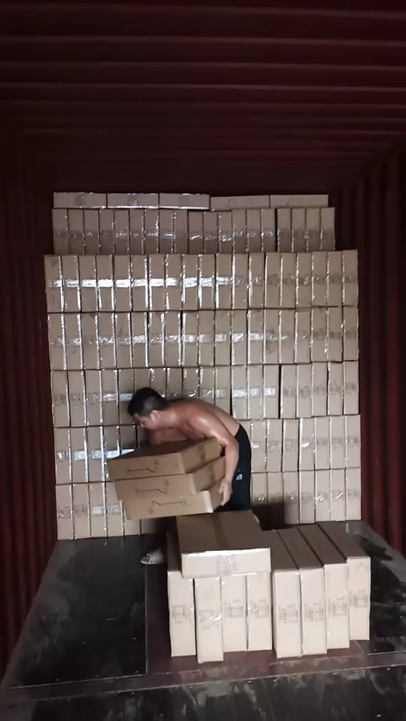 码至集装箱顶部的纸箱墙，工人正在搬运下一排
