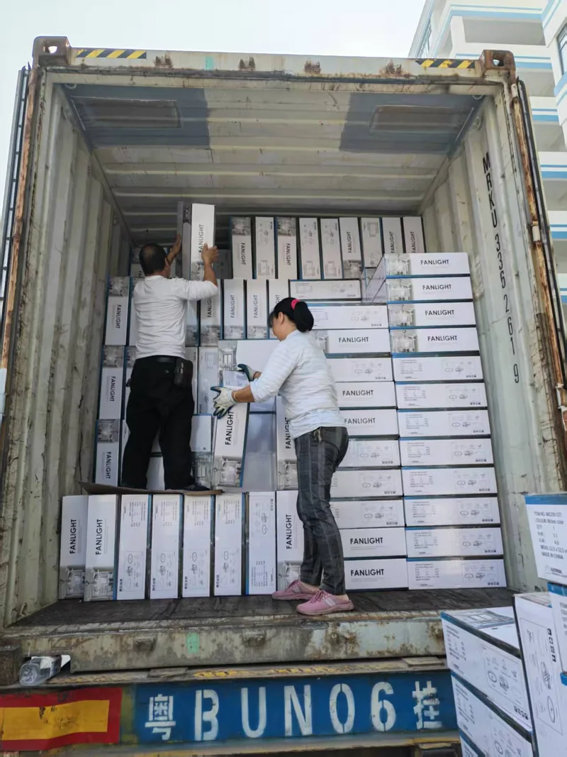 两名工人在集装箱内码放纸箱墙